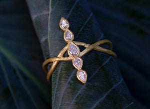 Diamond Line Ring by Laurie Kaiser available at Talisman Collection Fine Jewelers in El Dorado Hills, CA and online.Presenting our Diamond Line Ring, a masterpiece of design and craftsmanship. This ring showcases 0.31 total carats of pear-cut diamonds in a linear arrangement, gracefully intersecting with a pair of 18k gold intertwined vines. The result is a harmonious blend of modern sophistication and natural beauty, making it a timeless addition to your jewelry collection.