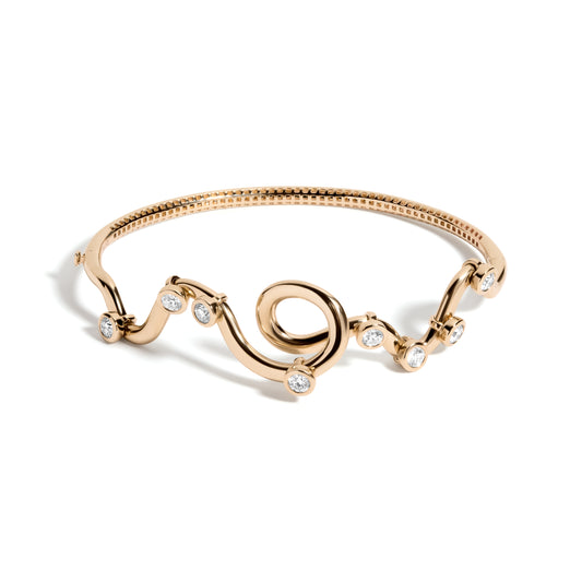 Rollercoaster Bangle Bracelet by Mined + Found available at Talisman Collection Fine Jewelers in El Dorado Hills, CA and online.  Experience the ride of life with the 14k yellow gold rollercoaster bangle! Featuring 0.80 cts of moveable diamonds that glide along a twisting and winding pathway, this bracelet is a whimsical journey from one side to the other. The inner gallery is designed with a rollercoaster track inspired pattern, adding a touch of playful flair. Keep the fun going with the easy side hinge a