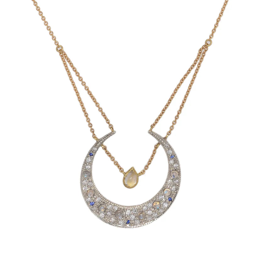 Sapphire & Diamond Selene Necklace by Unhada available at Talisman Collection in El Dorado Hills, CA and online. The Selene diamond moon necklace is aptly named after the Greek goddess and features a sterling silver pending encrusted with .34 cts of diamonds, complemented by blue sapphires and faceted rainbow moonstones. Adding to its elegance, a single pear-cut labradorite rests in the center of the crescent, suspended from an 18k yellow gold chain. The necklace can be adjusted to a length of 16 – 18”