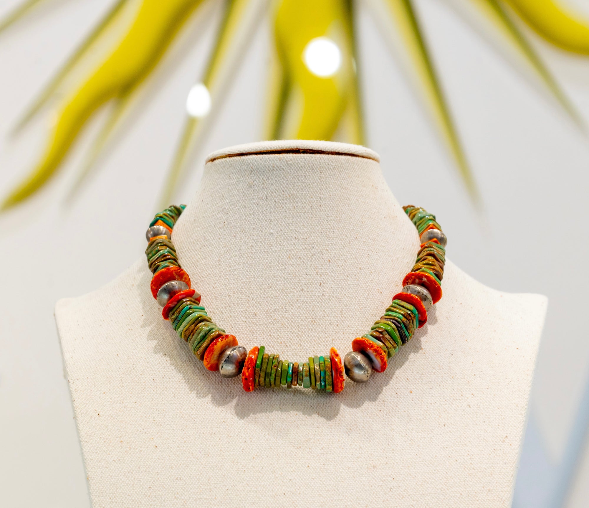 Native American Green Turquoise Necklace available at Talisman Collection Fine Jewelers in El Dorado Hills, CA and online. Stats: Adorn yourself with a masterpiece of culture and tradition. This necklace features strikingly layered stones, handcrafted by the renowned Navajo artist, Tommy Singer. A vibrant blend of purple spiny oyster shell, lapis, turquoise, and pale serpentine, delicately accented by sterling silver and red brass, perfectly symbolizes the rich cultural heritage of the Southwest.
