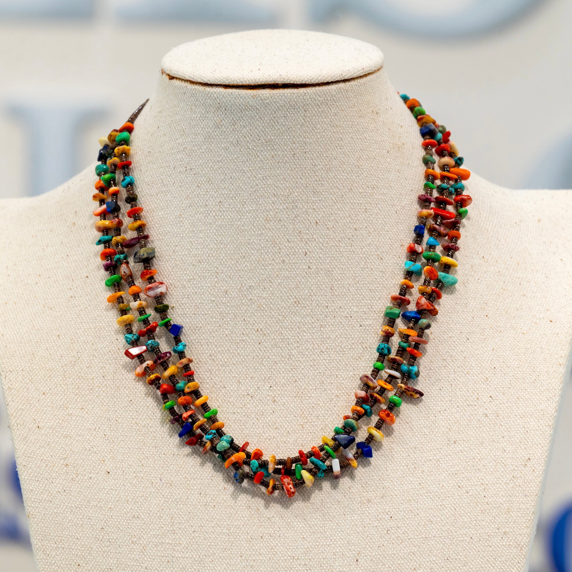 Native American 3 Strand Heishi Necklace available at Talisman Collection Fine Jewelers in El Dorado Hills, CA and online. This exquisite 3-strand necklace, measuring 18 inches in length, is a true representation of Native American artistry. Composed of baby brown olive heishi, accented with vibrant turquoise, lapis, and spiny oyster shell in four stunning shades, it exudes a sense of cultural authenticity and luxurious exclusivity