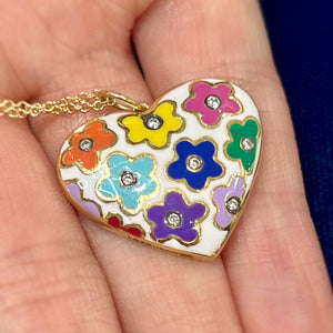Enamel Flower Heart Pendant by Lord Jewelry available at Talisman Collection Fine Jewelers in El Dorado Hills, CA and online. This 18k gold, white enamel heart pendant is a vibrant piece with a retro, pop art feel. This pendant features charming colored flowers, each with a sparkling diamond center totaling .12 carats. It's a playful and unique accessory that adds a burst of color and whimsy; perfect for those who appreciate a touch of joyful individuality.