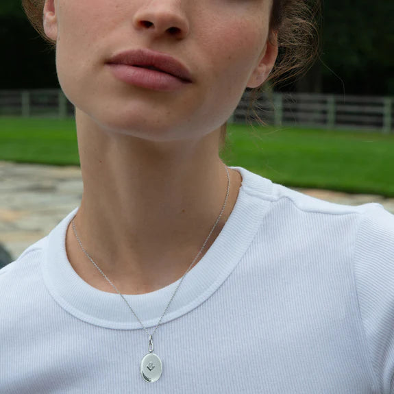 Silver Oval Locket with Diamonds by Monica Rich Kosann available at Talisman Collection Fine Jewelers in El Dorado Hills, CA and online. This sterling silver locket tells your story with a refined sparkle. Featuring pave-set white diamonds in a diamond-shaped pattern (.05 cts of FG/VS2 diamonds), the oval locket is finished with rhodium for lasting shine and protection from tarnishing. Measuring 1.5" tall and 1" wide, it hangs on an 18" silver mini diamond-cut chain with adjustable loops at 17” and 16” for 