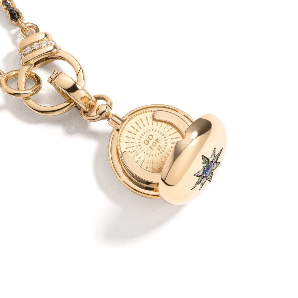 Direction Sapphire and Tsavorite Locket by Mined + Found available at Talisman Collection Fine Jewelers in El Dorado Hills, CA and online. Useful Objects&nbsp;are designed to captivate the eye, touch the heart, spark conversation and provide meaningful adornment; this spectacular locket is a beautiful example. From inside the 14k locket emerges a coin in smooth, satin finish yellow gold. On the one side, a sunburst dictates "GO FOR IT." The reverse, a serene moonscape, with the message "WAIT FOR IT." The ex