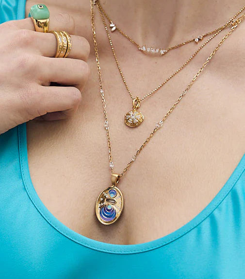 Star Eternal Double Sided Pendant by Meredith Young available at Talisman Collection Fine Jewelers in El Dorado Hills, CA and online. Shine bright with the Star Eternal Pendant by Meredith Young! Crafted with 18k gold and adorned with .49 cts of diamonds and 1.24 cts of white sapphire, this reversible pendant showcases a unique and playful design. One side depicts a star's birth in vibrant enamel, while the other side celebrates transitions with a supernova. Measures 1.33 inches from top to bottom.