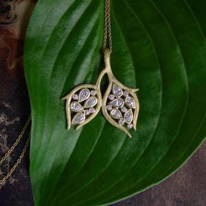Double Leaf and Vine Pendant Necklace by Laurie Kaiser available at Talisman Collection Fine Jewelers in El Dorado Hills, CA and online.The Double Leaf and Vine Pendant Necklace embodies the beauty of nature. The pendant is embellished with glistening pear-cut diamonds totaling .90 carats and .10cts of white round brilliant diamonds all set in 18k yellow gold subtly textured vines. The 20-inch chain makes it a perfect choice for layering, or worn alone, it highlights your décolletage.