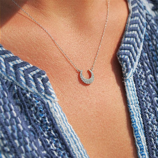 LOT:313 | TIFFANY & CO. - a diamond 'Metro' horseshoe pendant, on chain.