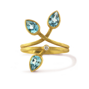 Swiss Blue Topaz Double Vine Ring by Laurie Kaiser available at Talisman Collection Fine Jewelers in El Dorado Hills, CA and online. This stunning ring, crafted in 18k yellow gold, is comprised of textured vines that intertwine and features three faceted, pear-cut Swiss blue topaz gems and a white brilliant diamond totaling 0.03 ctw. The  vibrant colored stones create unique look, perfect for those who appreciate distinctive and elegant jewelry.