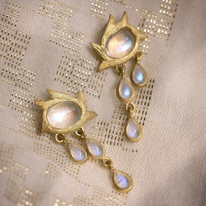 Rainbow Moonstone Star Flower Earrings by Laurie Kaiser available at Talisman Collection Fine Jewelers in El Dorado Hills, CA and online. The Star Flower Earrings are a beautiful blend of modern sophistication and bohemian charm. Three asymmetrical cabochon teardrops gracefully hang from an oval cabochon moonstone framed in 18k yellow gold vines. These earrings are a must-have for any jewelry lover.