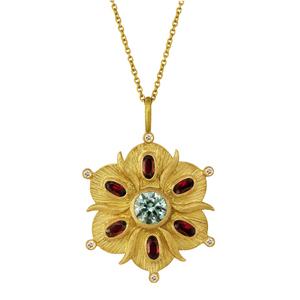 Scalloped Bloom Necklace by Laurie Kaiser available at Talisman Collection Fine Jewelers in El Dorado Hills, CA and online. The Scalloped Bloom Necklace evokes an antique feel and features a flower-shaped pendant with a soft green spinel in the center. The petals are adorned with deep red garnets and 0.06 cts of white brilliant diamonds. The pendant is crafted in 18k yellow gold and hangs on a fine 17" chain and captures the beauty of a bygone era.