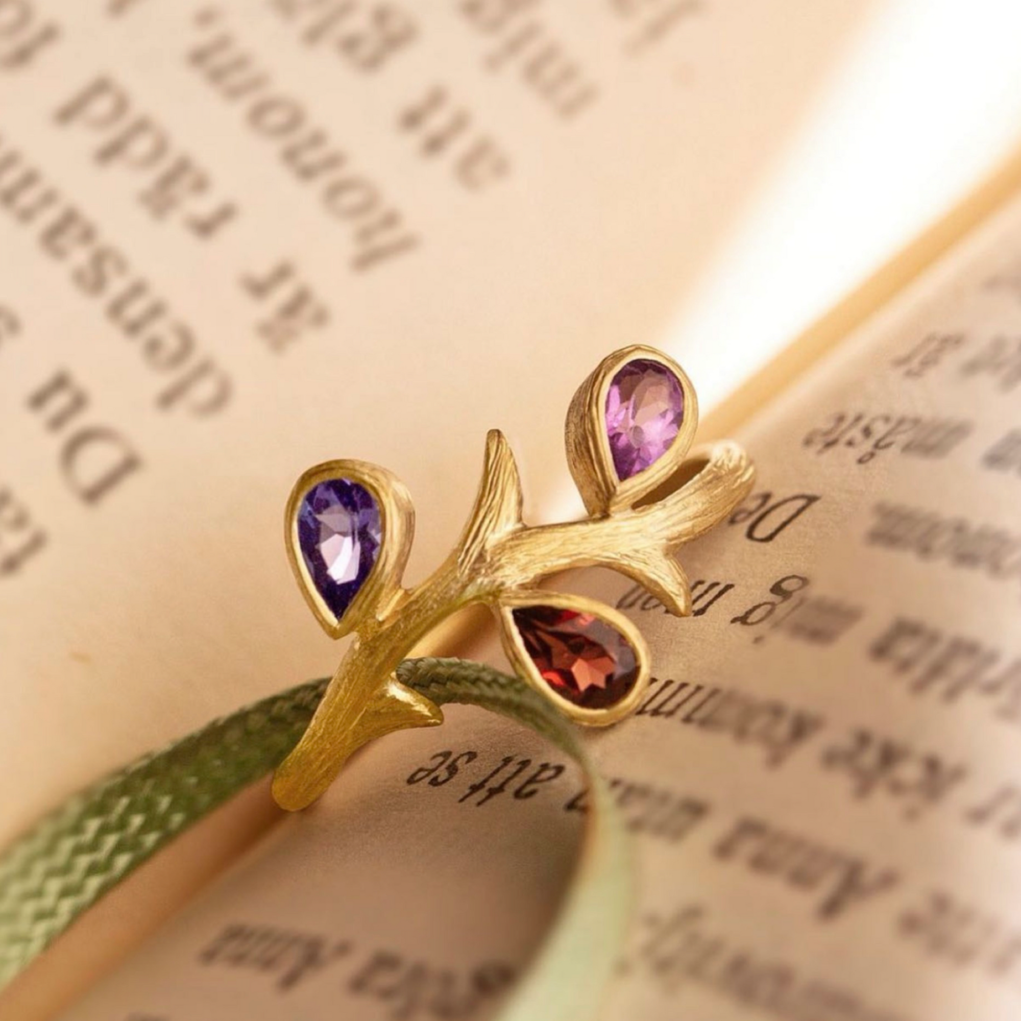 Vine Multi-Color Ring by Laurie Kaiser available at Talisman Collection Fine Jewelers in El Dorado Hills, CA and online. This delicate 18k yellow gold ring features three pear-shaped gems arranged on a vine inspired band. The stones - tanzanite, garnet, and amethyst - complement each other creating a perfect harmony of colors.