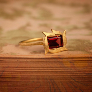 Vine Framed Garnet Ring by Laurie Kaiser available at Talisman Collection Fine Jewelers in El Dorado Hills, CA and online. This Vine Framed Garnet Ring features an emerald-cut garnet that is beautifully surrounded by 18k yellow gold vines on a gold band. The simplicity of the design allows the vibrant color of the garnet to be the centerstage.
